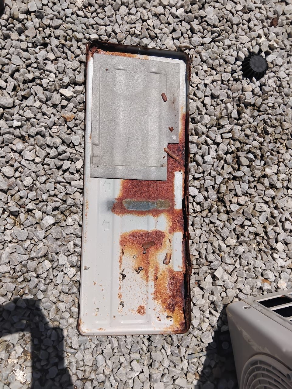 Rusted cover panel removed from an aircon outdoor unit