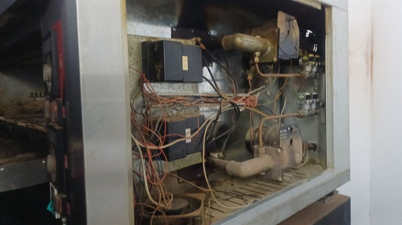 Burner and ignition compartment of a commercial gas deck oven opened for repair in Randfontein