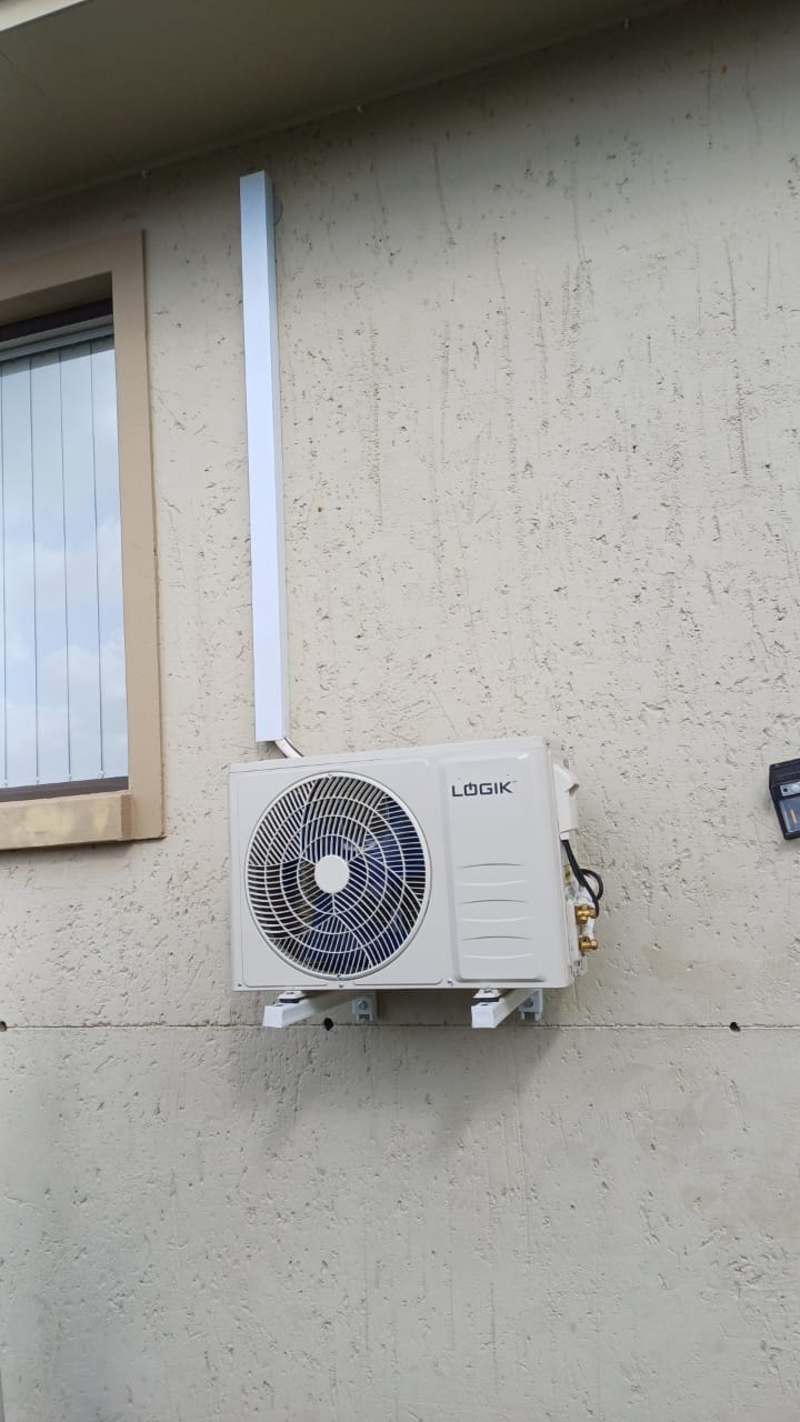 Logik split aircon outdoor unit installed on wall brackets with neat white trunking in Centurion