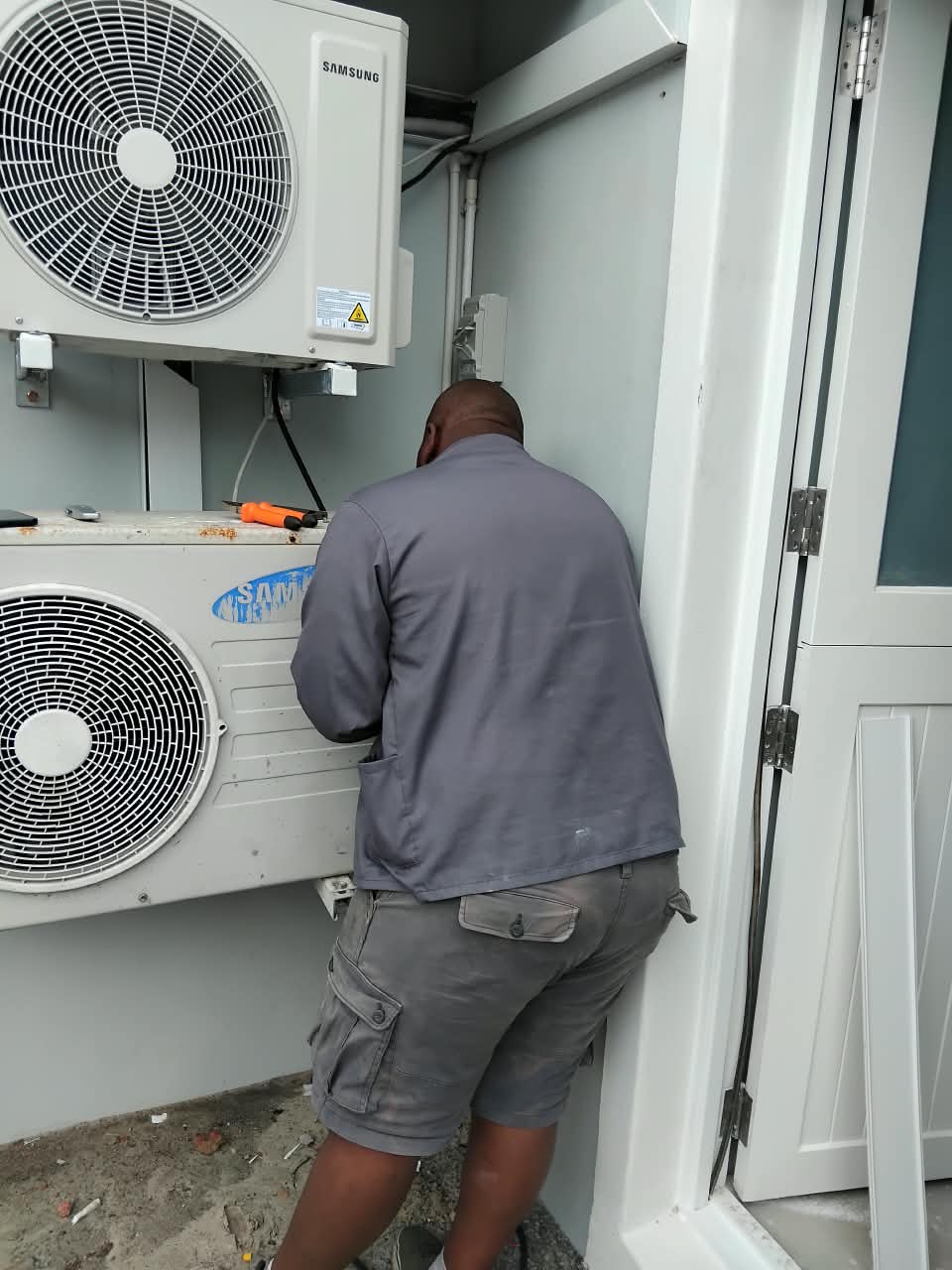 Absolute Repairs technician connecting a Samsung inverter aircon outdoor unit during an installation in Midrand