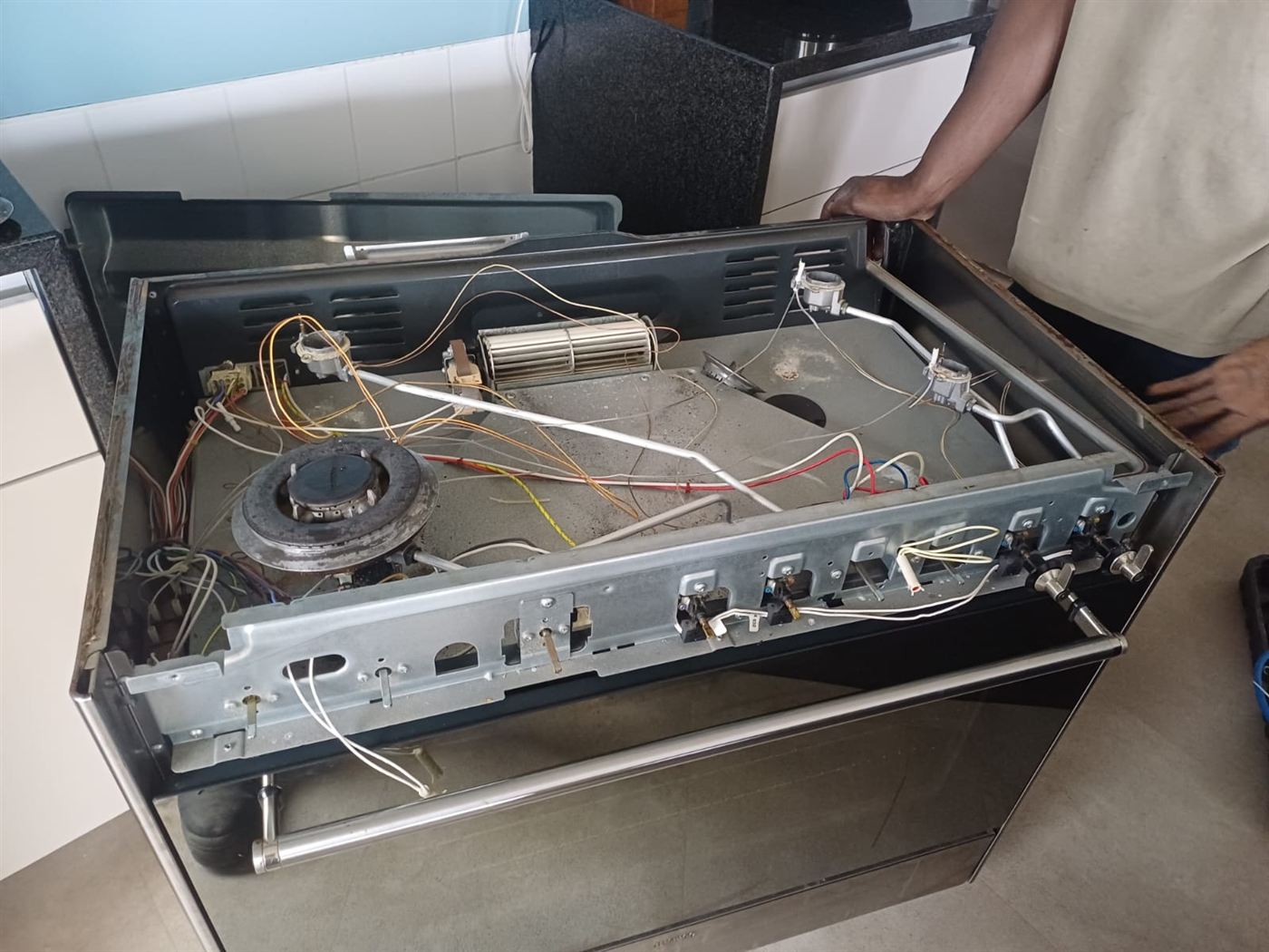Smeg dual-fuel cooker with the hob lifted to replace a gas burner thermocouple