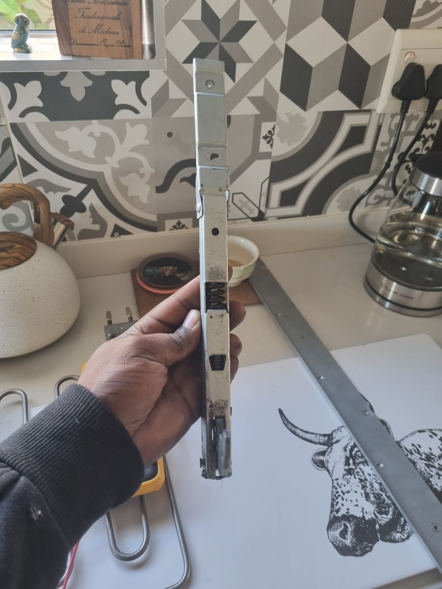 Worn Smeg oven door hinge holder removed during a repair in Fourways