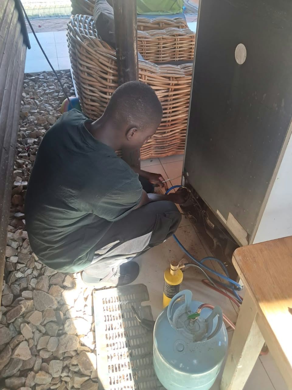 Technician repairing a gas leak and regassing a glass-door drinks cooler in Steyn City