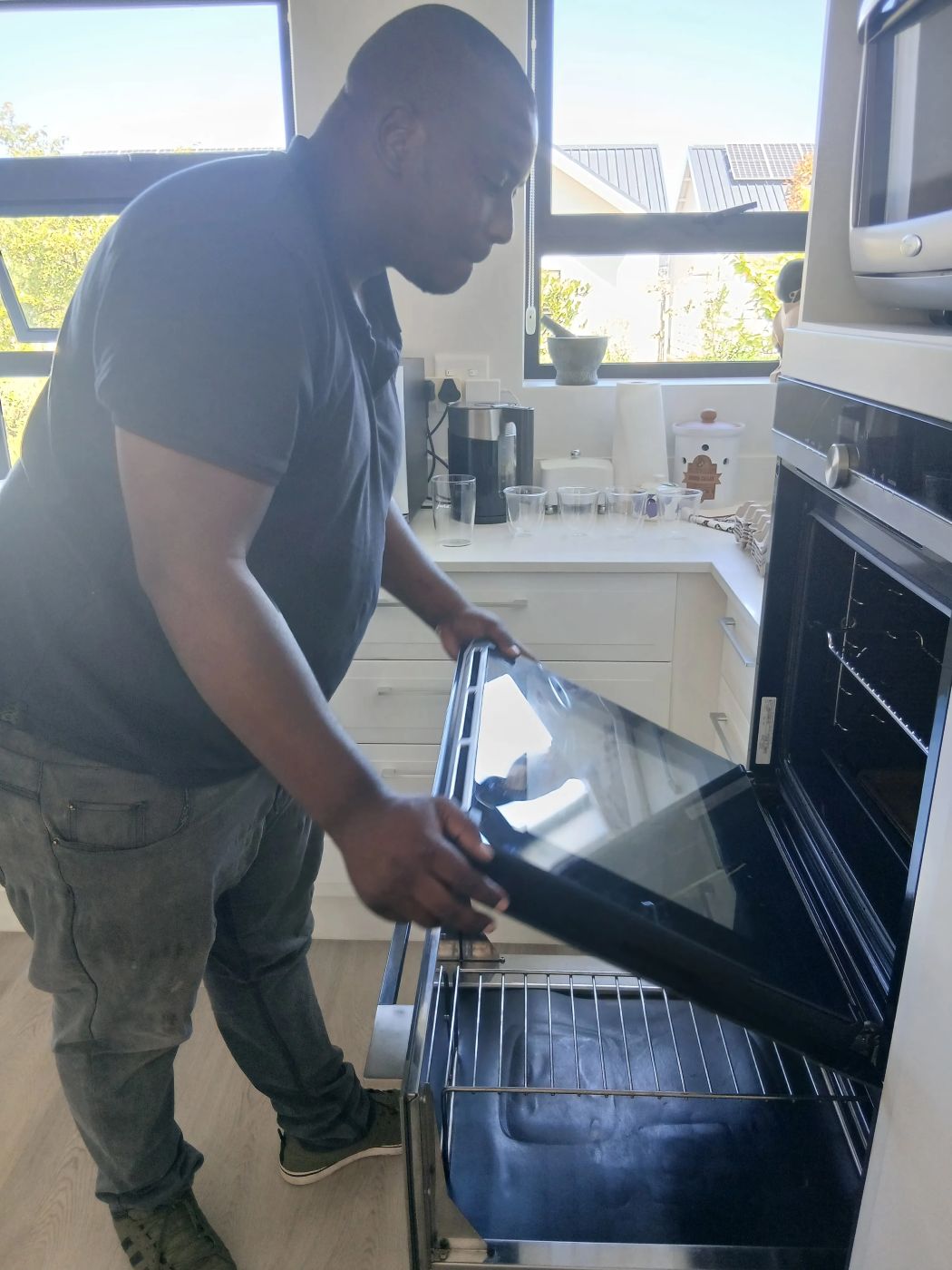 Absolute Repairs technician refitting the door on a Siemens built-in oven in Bryanston